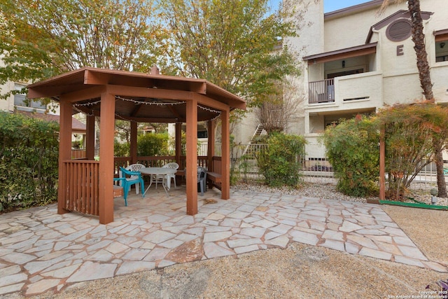 view of patio with a gazebo and a balcony