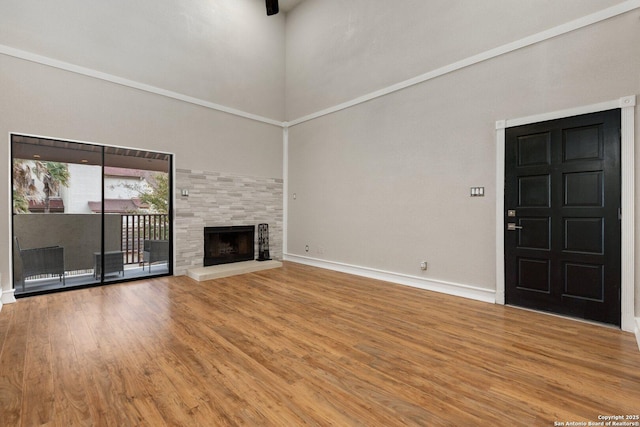 unfurnished living room with a high ceiling, a fireplace, and hardwood / wood-style floors