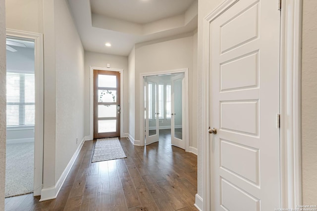 foyer with a tray ceiling, french doors, and dark hardwood / wood-style floors