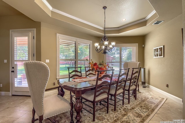 dining space featuring a notable chandelier, a raised ceiling, ornamental molding, and a wealth of natural light