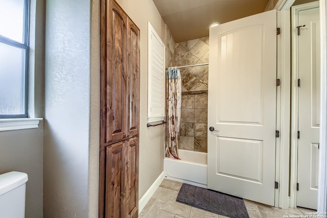 bathroom with plenty of natural light, toilet, and shower / bathtub combination with curtain