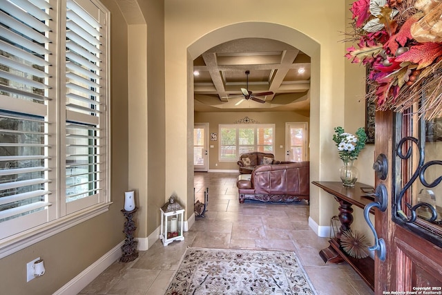 foyer entrance with ceiling fan, beamed ceiling, and coffered ceiling