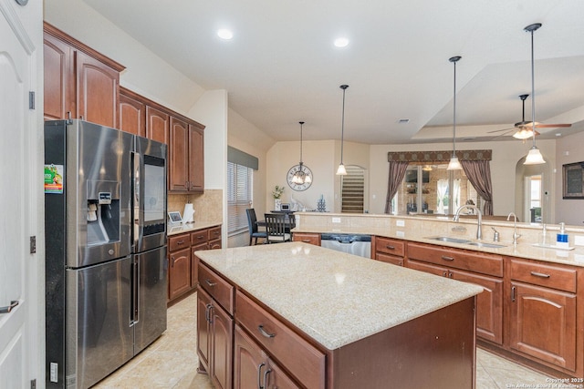 kitchen with stainless steel appliances, ceiling fan, sink, decorative light fixtures, and a center island