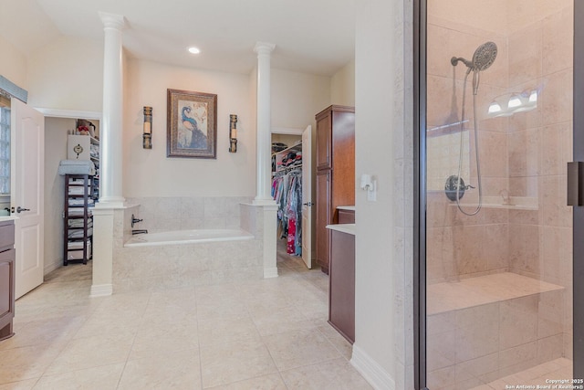 bathroom with tile patterned floors, vanity, separate shower and tub, and ornate columns