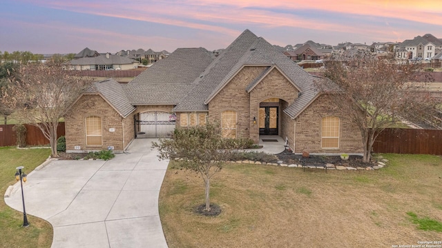 french country style house featuring french doors and a yard