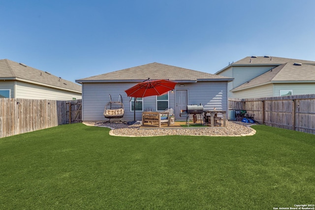 rear view of house featuring a yard and a patio