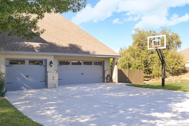 604 Hannahs Run, New Braunfels, TX 78130 - view of property exterior with concrete driveway, roof with shingles, an attached garage, stone siding, and an outdoor structure
