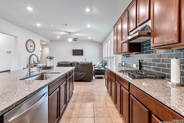 kitchen featuring sink, light stone counters, extractor fan, light tile patterned flooring, and appliances with stainless steel finishes