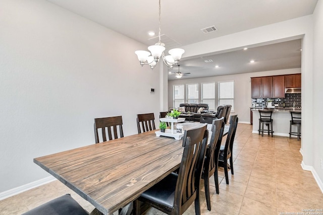 dining area featuring light tile patterned floors and ceiling fan with notable chandelier