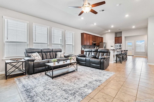 tiled living room featuring ceiling fan and vaulted ceiling