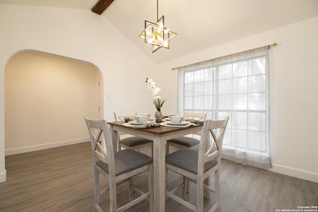 dining area featuring dark hardwood / wood-style flooring, vaulted ceiling with beams, and a notable chandelier