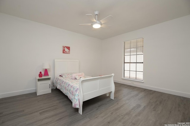 bedroom with dark hardwood / wood-style flooring and ceiling fan