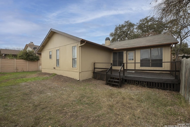 rear view of house featuring a lawn and a wooden deck