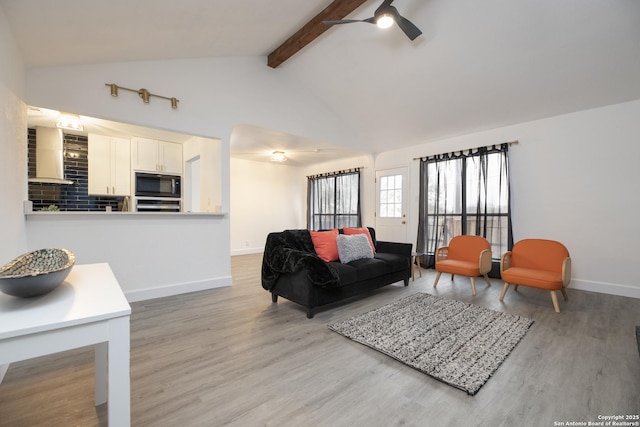 living room featuring hardwood / wood-style flooring, lofted ceiling with beams, and ceiling fan