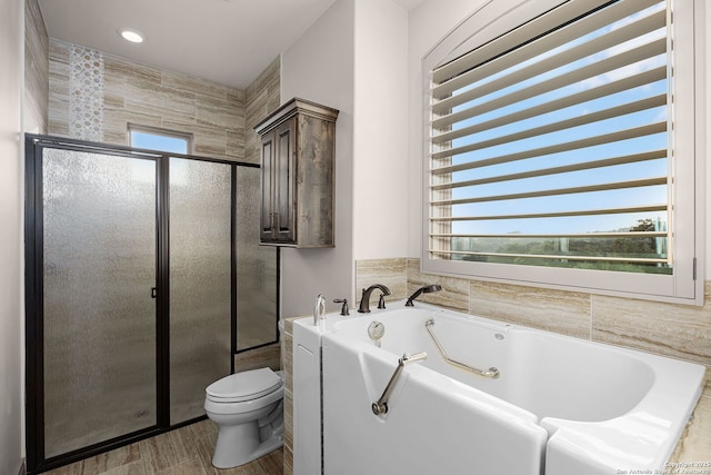 bathroom featuring separate shower and tub and toilet