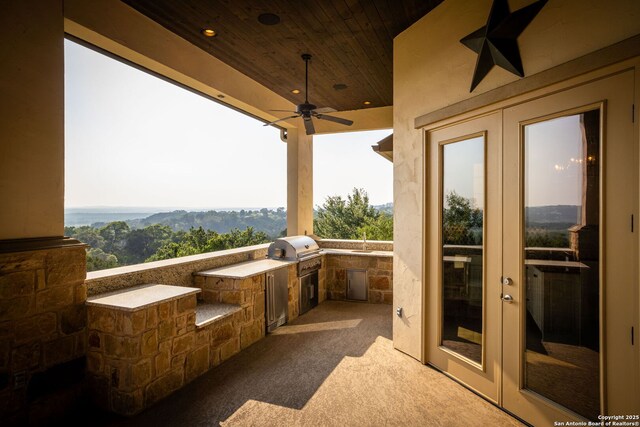 view of patio featuring french doors, a grill, ceiling fan, and exterior kitchen