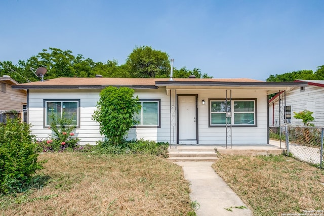 ranch-style house with a front yard and covered porch