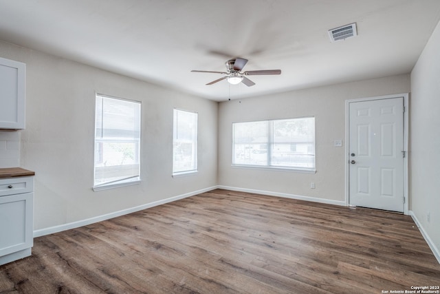 unfurnished dining area featuring ceiling fan and wood-type flooring