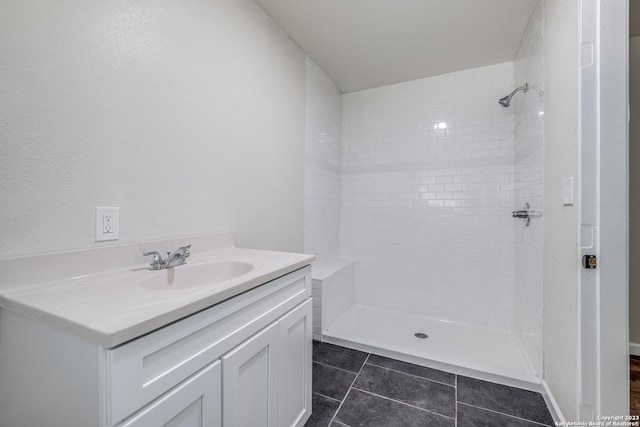 bathroom with tile patterned floors, vanity, and tiled shower