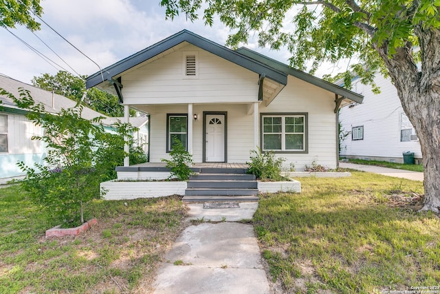 bungalow-style home featuring a porch and a front lawn