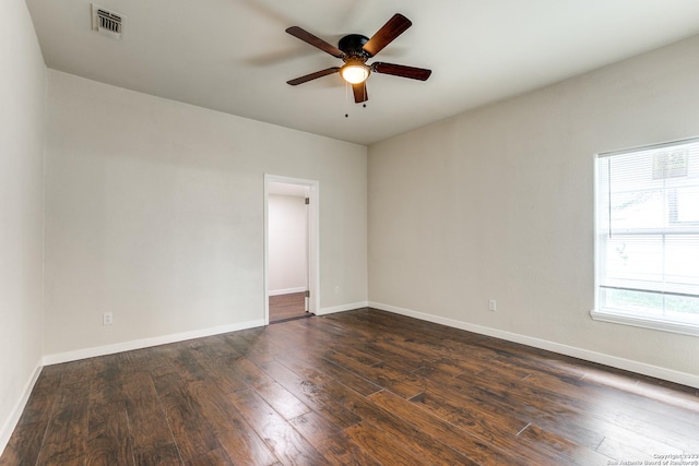 empty room with ceiling fan, dark hardwood / wood-style flooring, and a wealth of natural light