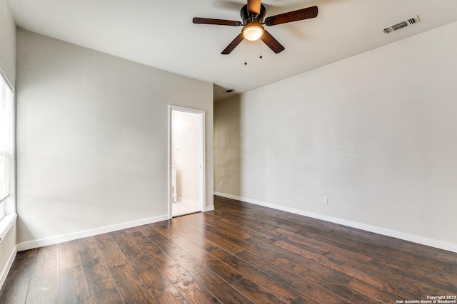 empty room with ceiling fan and dark hardwood / wood-style flooring