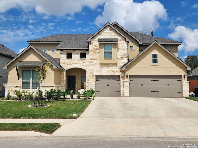 view of front of home with a garage and a front lawn