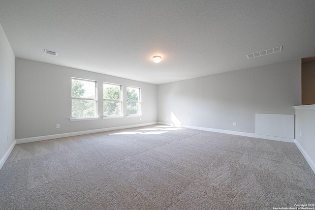 carpeted spare room with a textured ceiling