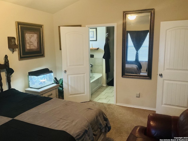 bedroom featuring light tile patterned flooring, connected bathroom, and vaulted ceiling