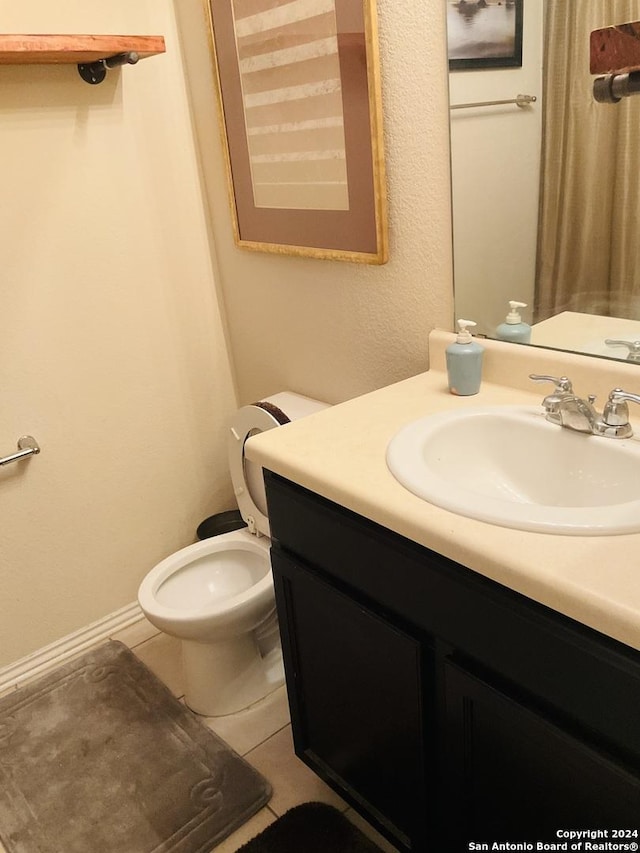 bathroom with tile patterned flooring, vanity, and toilet