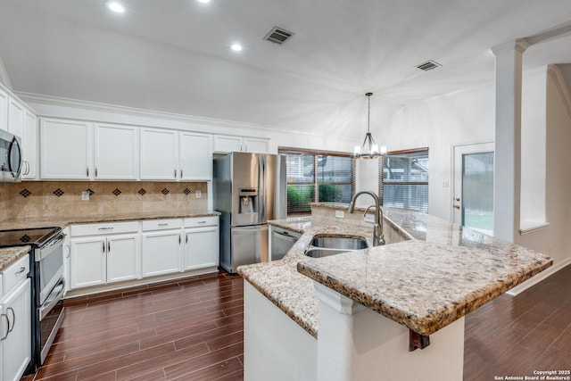 kitchen featuring a center island with sink, sink, decorative light fixtures, white cabinetry, and stainless steel appliances