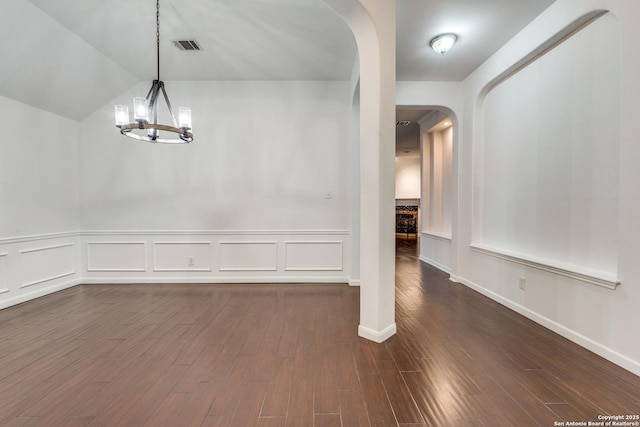 unfurnished dining area with dark hardwood / wood-style floors, vaulted ceiling, and an inviting chandelier