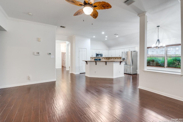 unfurnished living room with ceiling fan with notable chandelier, dark hardwood / wood-style floors, lofted ceiling, and ornamental molding