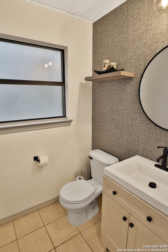 bathroom with tile patterned floors, vanity, a textured ceiling, and toilet