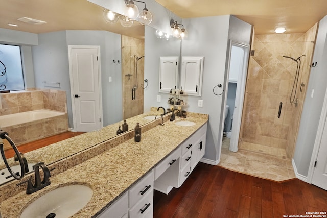 bathroom featuring hardwood / wood-style floors, vanity, and shower with separate bathtub