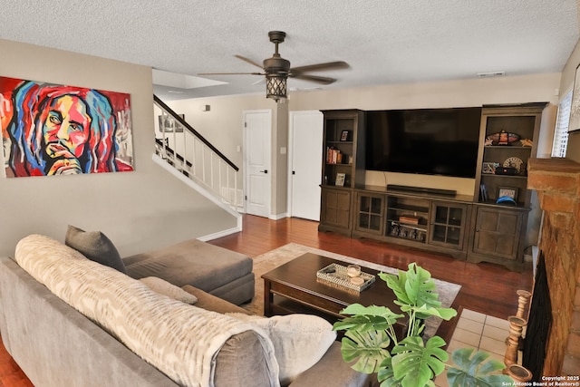 living room with ceiling fan and a textured ceiling