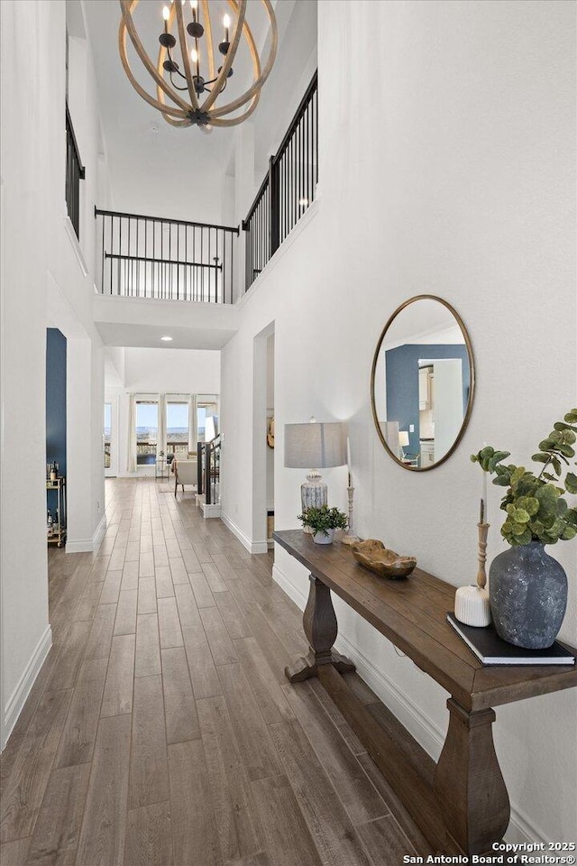 interior space with hardwood / wood-style flooring, a high ceiling, and a chandelier