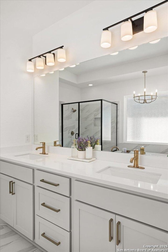 bathroom featuring vanity, an inviting chandelier, and a shower with shower door