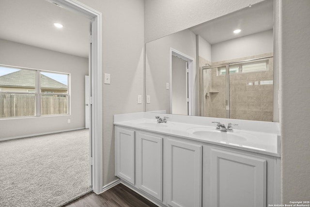 bathroom featuring hardwood / wood-style floors, vanity, and a shower with shower door