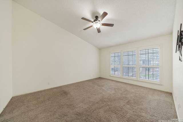 carpeted empty room featuring lofted ceiling, ceiling fan, and a textured ceiling