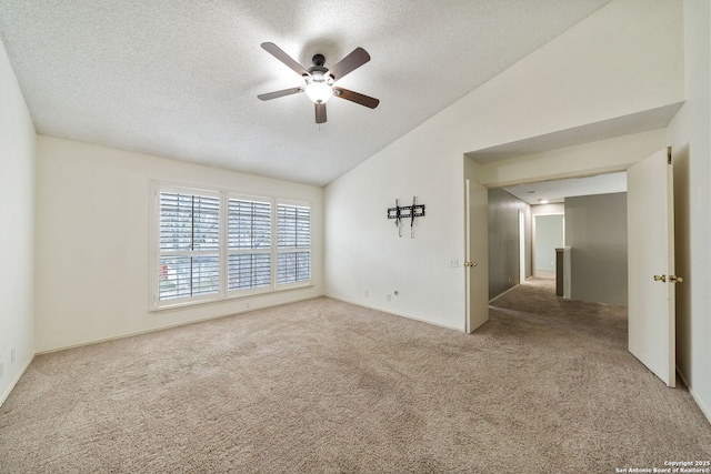 spare room with ceiling fan, carpet, lofted ceiling, and a textured ceiling