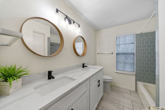 full bathroom featuring toilet, vanity, tiled shower / bath combo, and tile patterned flooring