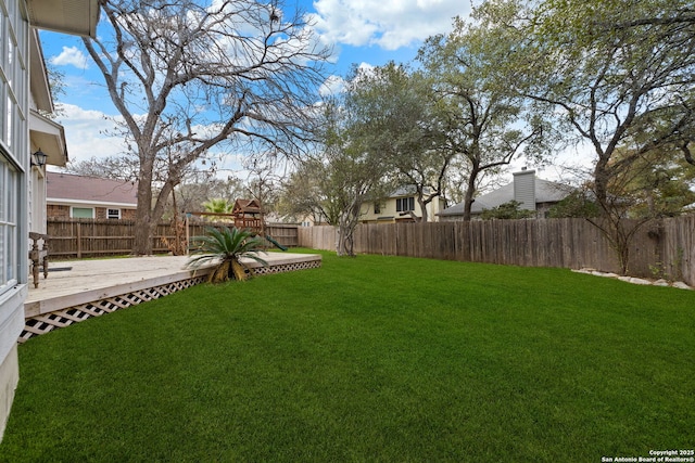 view of yard featuring a deck and a playground