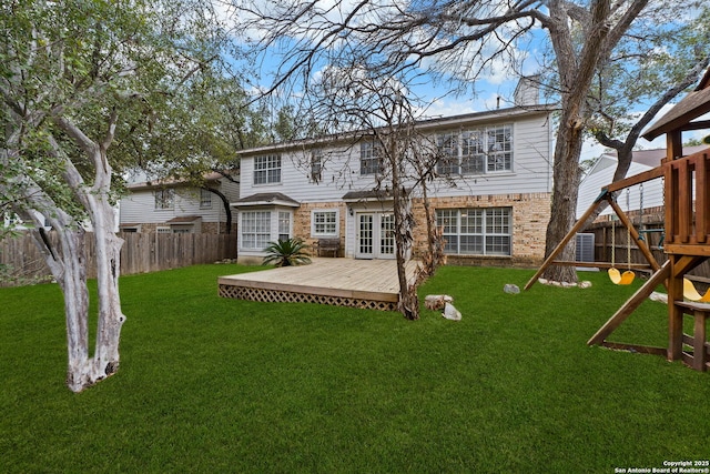 rear view of house featuring a lawn and a deck