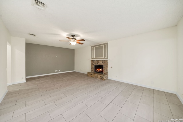 unfurnished living room featuring ceiling fan, a textured ceiling, and a fireplace