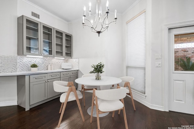 dining room with crown molding, dark hardwood / wood-style flooring, breakfast area, and an inviting chandelier