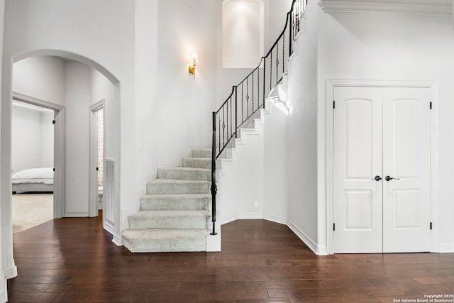 stairs featuring wood-type flooring and ornamental molding