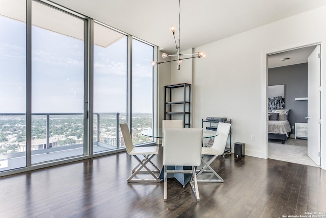 dining space with plenty of natural light, dark wood-type flooring, a notable chandelier, and a wall of windows