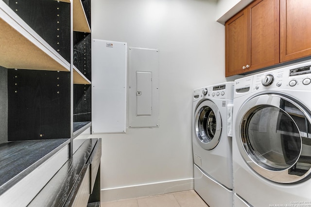 washroom with light tile patterned floors, washing machine and dryer, cabinets, and electric panel