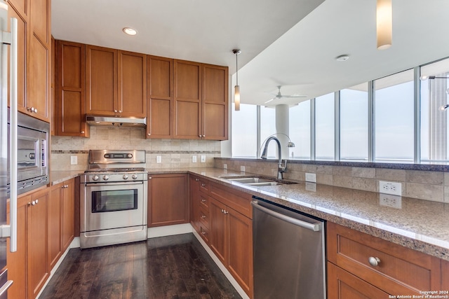 kitchen with sink, dark wood-type flooring, ceiling fan, appliances with stainless steel finishes, and hanging light fixtures